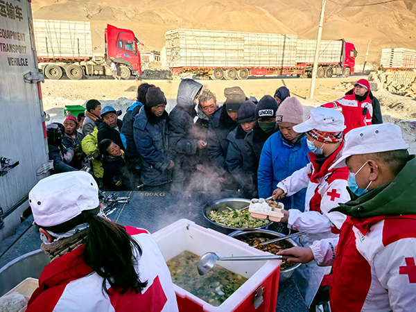 工作人員正在為村民分發(fā)熱氣騰騰的餐食。中國紅十字會總會供圖
