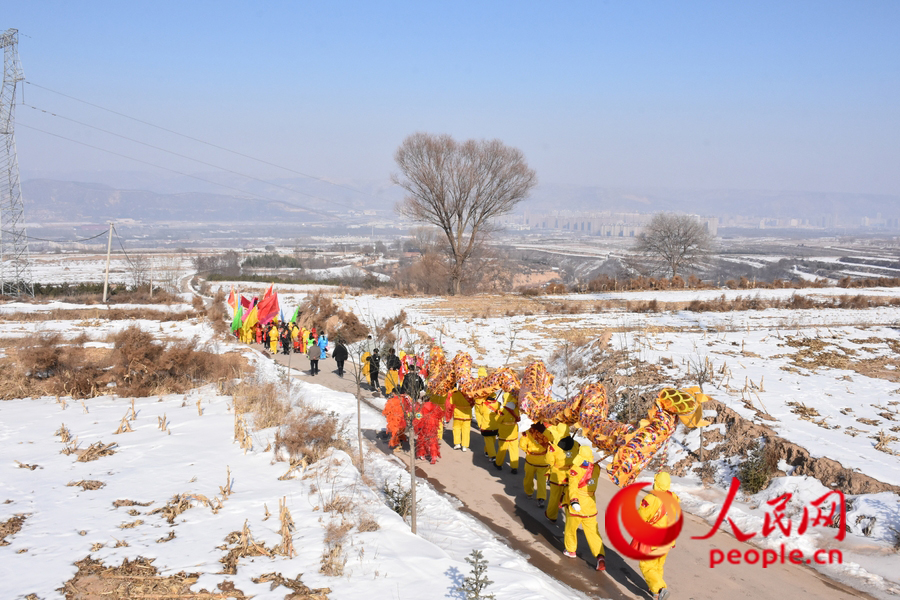 社火隊(duì)行走在雪后的黃土高原。人民網(wǎng) 劉文邦攝
