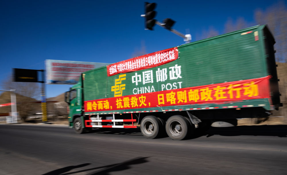2025年1月8日，在日喀則，中國郵政的抗震救災(zāi)物資運(yùn)輸車輛向震中方向駛?cè)?。新華社記者 丁增尼達(dá) 攝